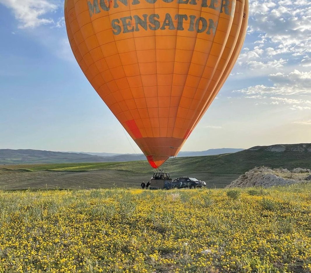 Hot air balloon over blooming fields near the village of Çat
